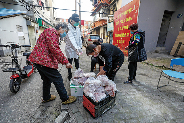 2020年3月18日湖北省武漢市的隔離居民正在領取配發的豬肉。Getty Images