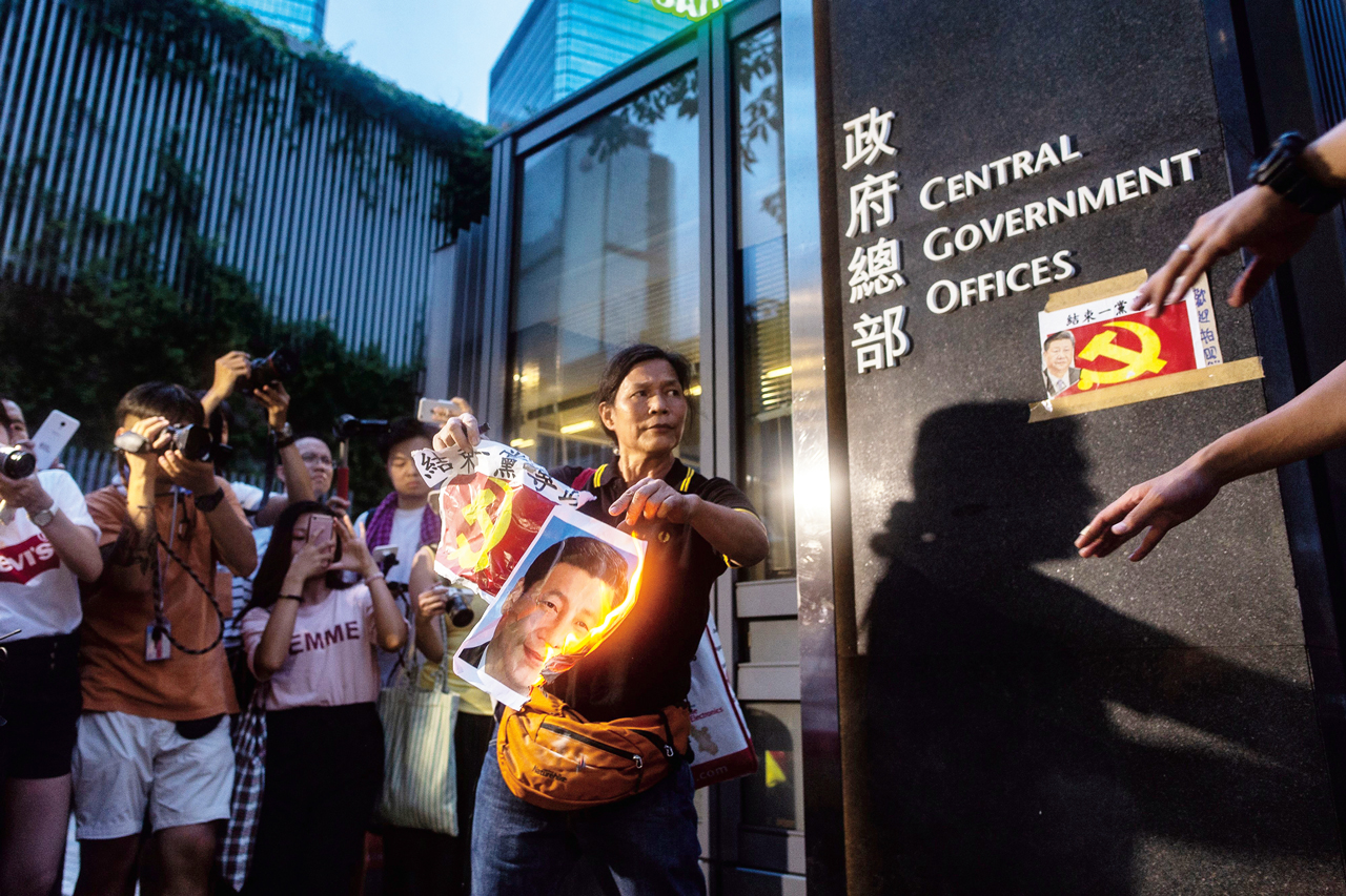 香港民主人士，號稱「女長毛」的雷玉蓮，5月18日舉行個人遊行。圖為2018年7月1日，雷玉蓮參加香港主權移交21週年抗議遊行後，在香港特別行政區政府總部外焚燒中國國家主席習近平的肖像。Getty Images
