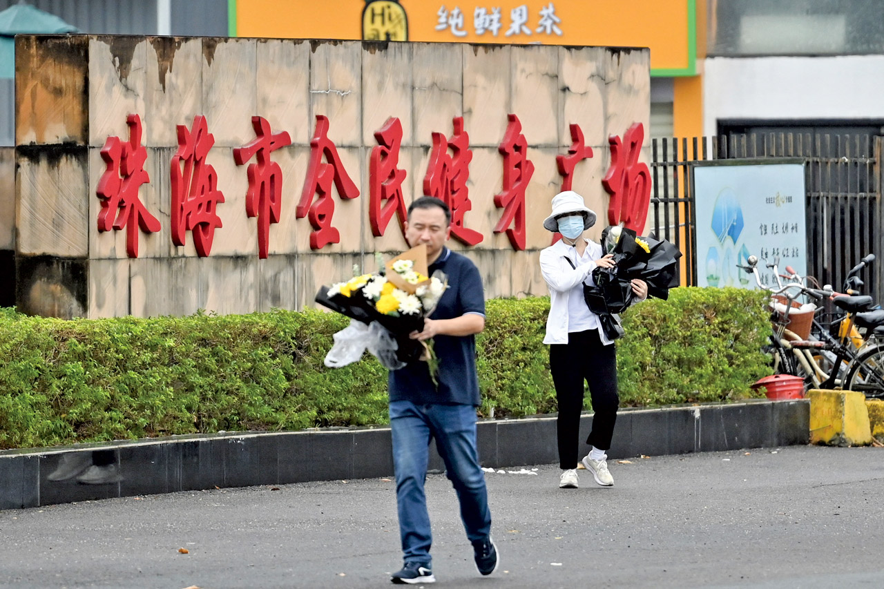 珠海撞人慘案事發隔日廣東省委立即召開維穩會議，並迅速清除現場悼念物品。圖為正在清理哀悼花束的政府人員。Getty Images