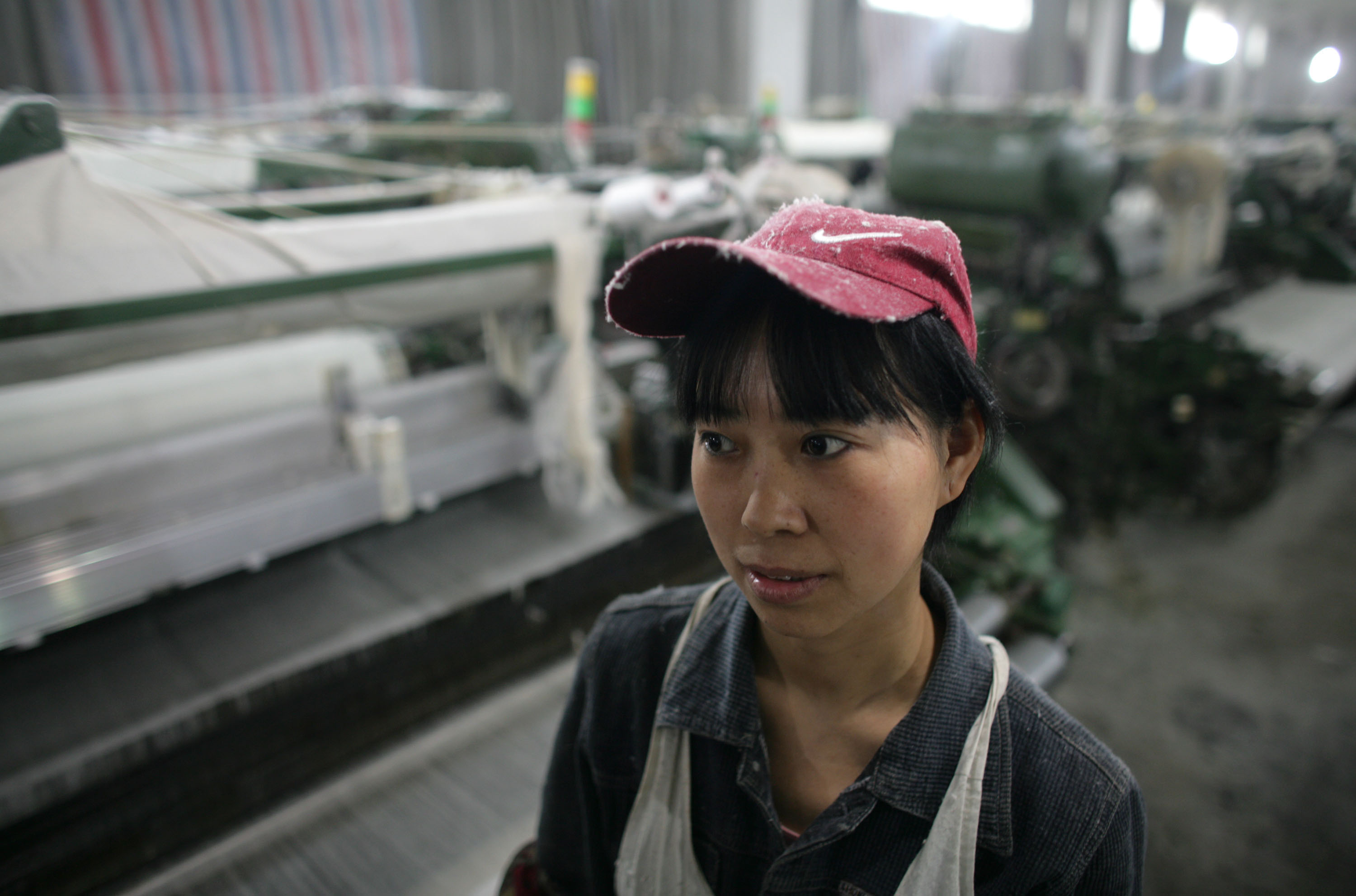 2月18日一名女工在重慶的一家紡織工廠工作。據中國官方預估，由於中國對外出口銳減，工廠倒閉潮將導致2,000萬農民工失業。